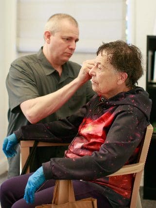 Dr. Jonathan Lipschutz helping a senior female with hearing aid fitting